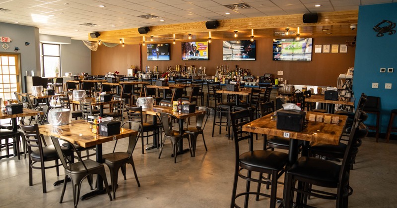 Interior, tables and chairs, tv screens on the wall