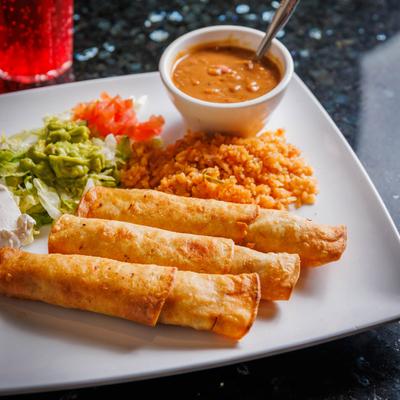 Chicken fried tortilla rolls, with rice, beans, sour cream and guacamole