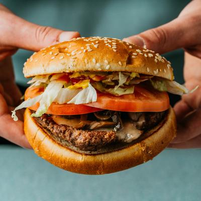 Hands holding the hero burger.