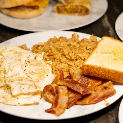 Fried eggs, bacon, hash browns, and toast.