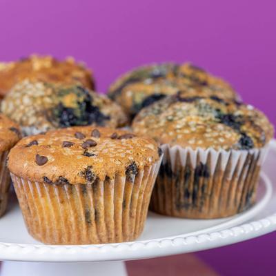 Chocolate chip muffins and blueberry muffins on a white stand.