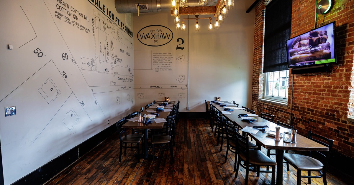 Rustic interior - brick walls, wooden floors, drawings on the wall, a chandelier-exposed bulbs
