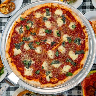 Margherita pizza topped with basil and mozzarella.