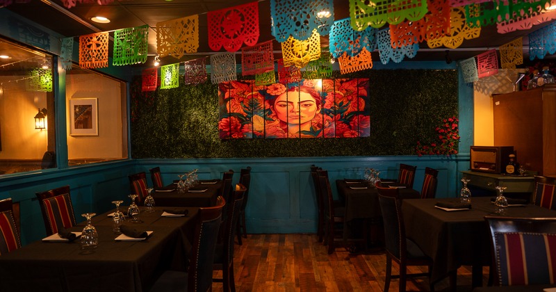 Cozy Mexican-style restaurant interior, dining area decorated with hanging paper ornaments