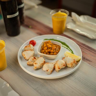 Chicken malai kebab with a side of chickpeas paired with mango lassi.