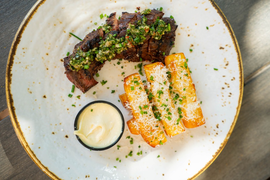 8oz wood-grilled hanger steak served with crispy duck confit fries, lemon aioli, and topped with mint salsa Verde