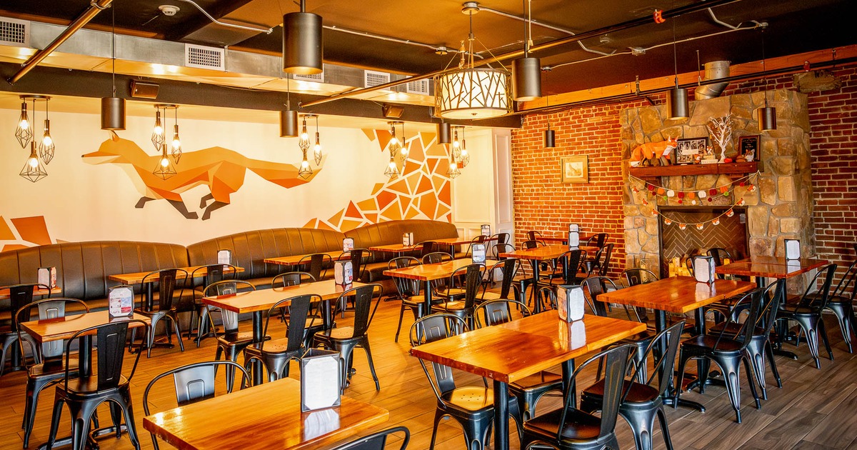 Interior, tables and chairs in dining area with decorated wall