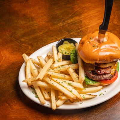 Bacon cheeseburger, with onion ring, BBQ sauce, and fries.