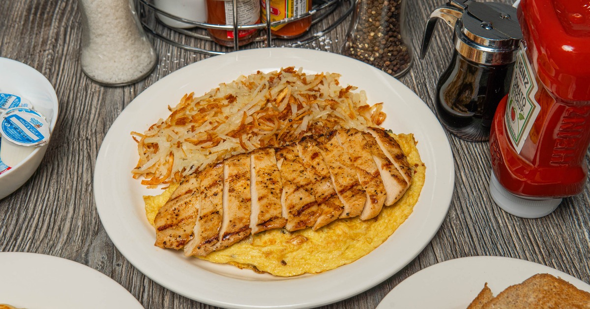 Grilled chicken on an omelet served with hash browns