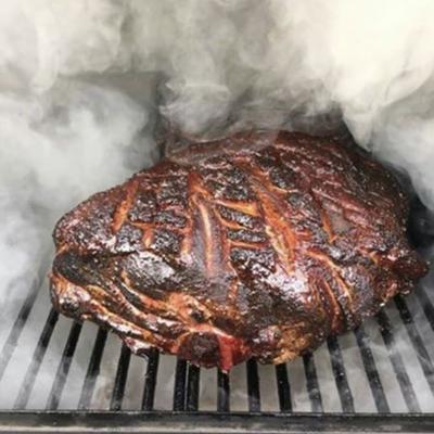 Piece of meat being smoked on a grill.