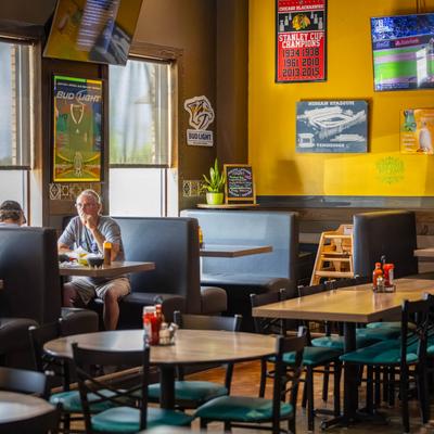 Colorful interior of a sports-themed restaurant with booth and standard seating.