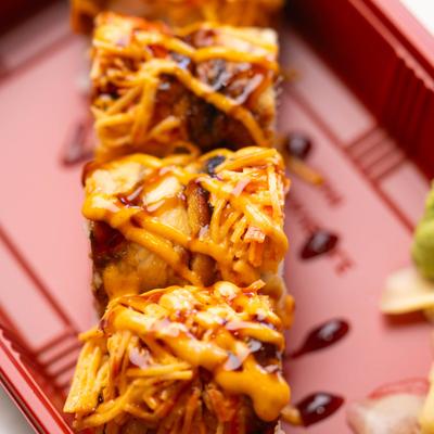 Sushi rolls topped with eel sauce and spicy mayo.