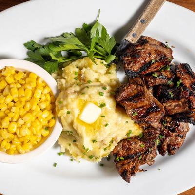 Steak tips, mashed potatoes, and corn.