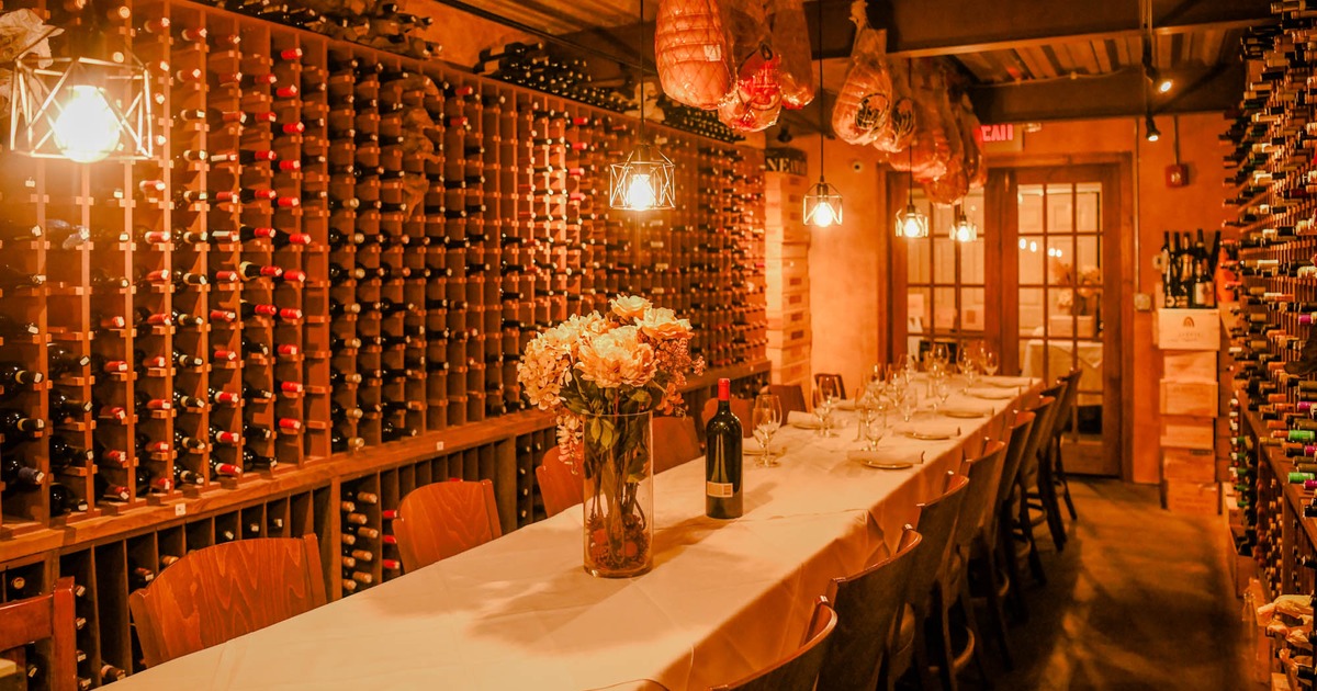 Fully set table between wine racks