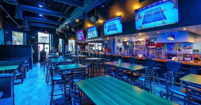 Spacious and cozy sports bar interior space, seating area and bar with a long counter