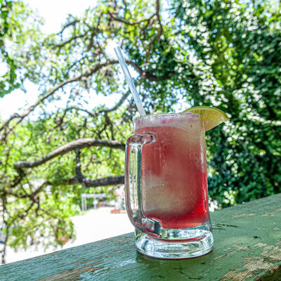 Frozen cocktail in glass mug on an outdoor deck.