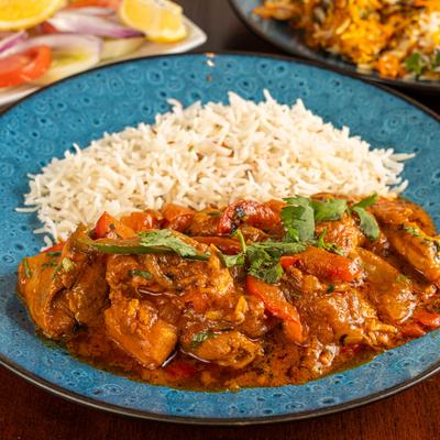 Chicken tikka masala and basmati rice on a blue plate.