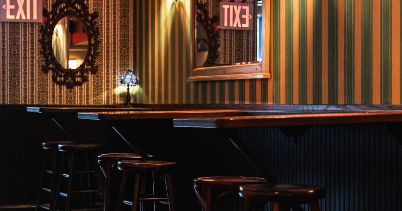 Interior, high tables and chairs near wall