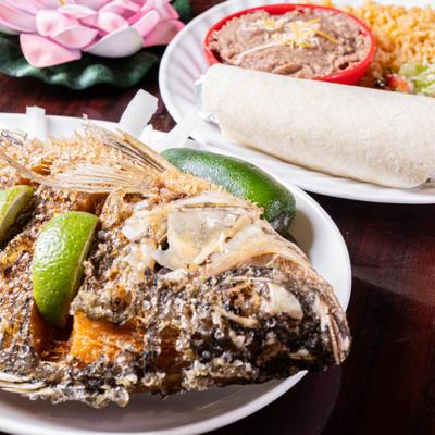 Fried tilapia served with rice, beans, tomato salsa, and Mexican salad.