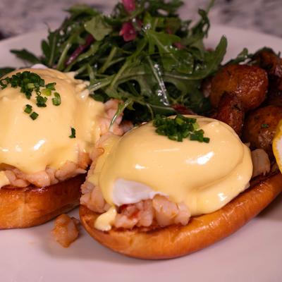 Lobster Benedict with herb salad and brunch potatoes.