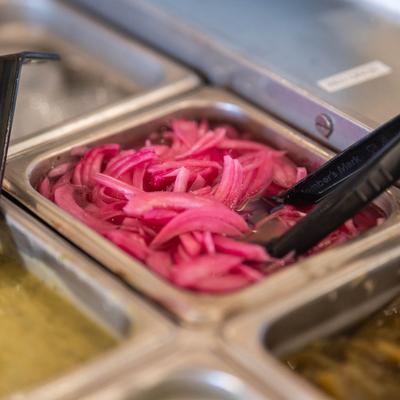 Close-up of a buffet serving with sliced pickled red onions.