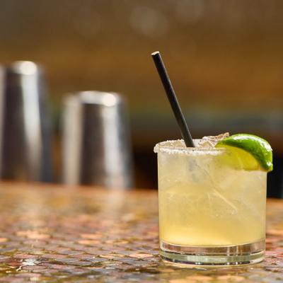 Margarita served in a salt-rimmed rocks glass with lime wedge garnish.