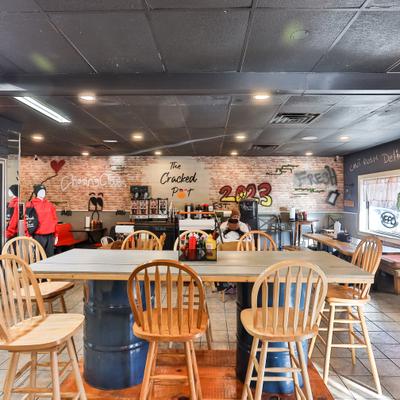 Rustic industrial style interior with high-top wooden tables and chairs.