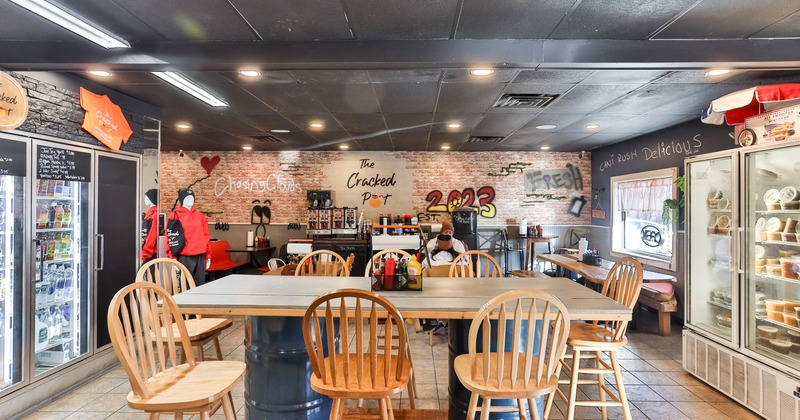 Casual dining space with a long table and glass-front refrigerators on the left and right sides