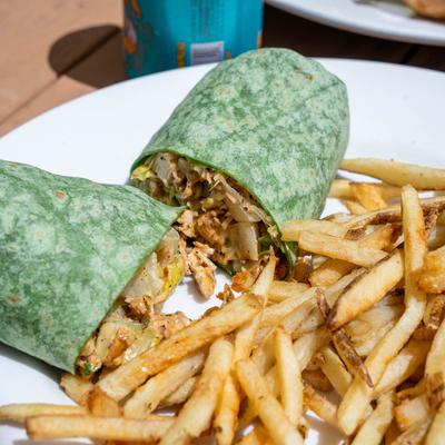 Blackened chicken Caesar wrap served with fries.