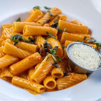 Vodka rigatoni, served, closeup.