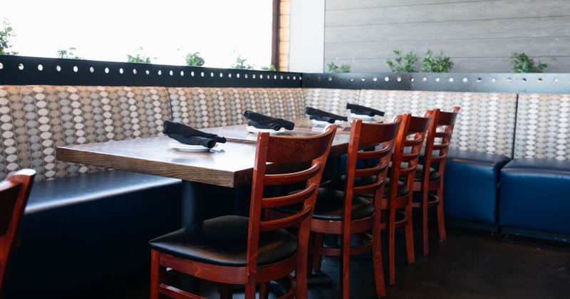 Interior, tables with banquette seating and chairs ready for guests