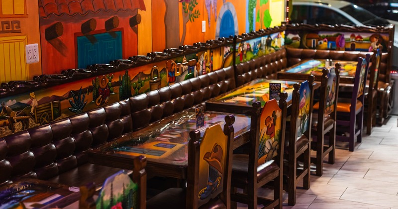 Colorful restaurant interior with mural-style walls and art-covered tables
