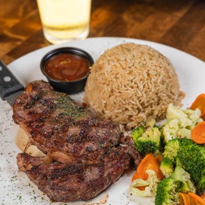 Ribeye steak with veggies, rice, and dipping sauce.