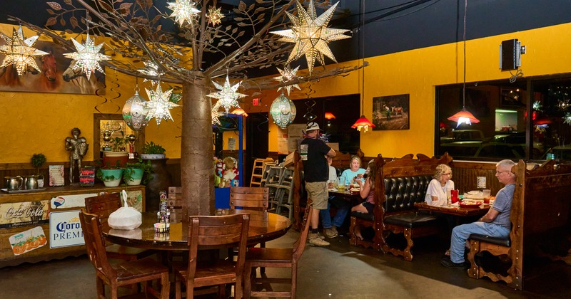 Round wooden table,chairs, booths behind