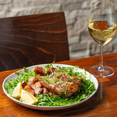 Chicken Cotoletta and white wine in the glass