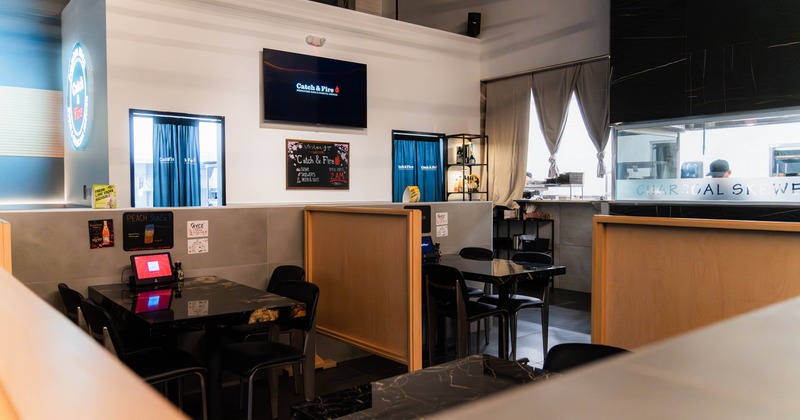 Interior - dining tables, a digital menu & a chalkboard with promotional information