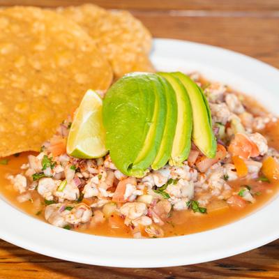 Ceviche topped with avocado, served with crispy tortillas and lime.
