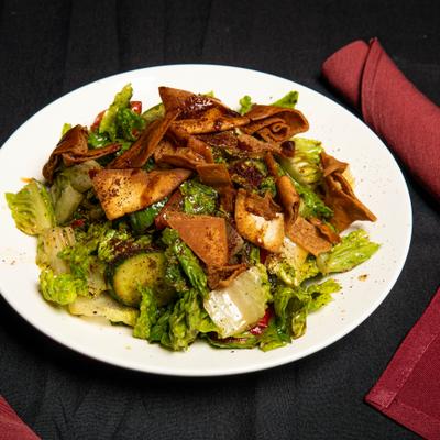 Salad with pita chips, mixed greens, tomatoes, and cucumbers.