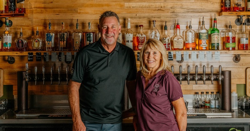 Owners posing behind the bar