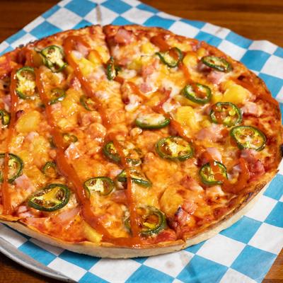 Pizza with ham, pineapple, jalapeno, and honey sriracha glaze.