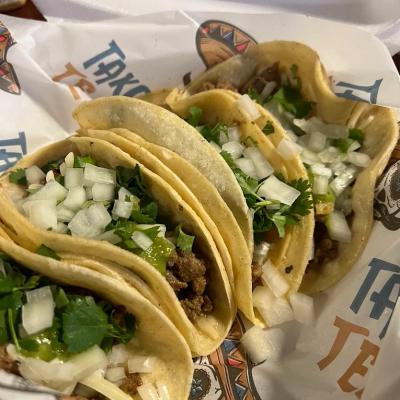 Portion of four tacos, closeup.