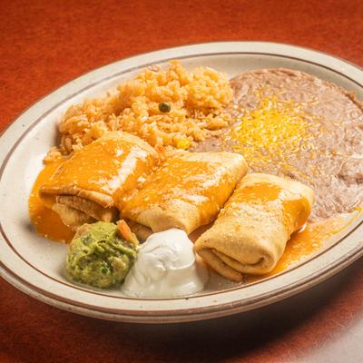 Chimichanga served with rice, refried beans, sour cream, and guacamole.