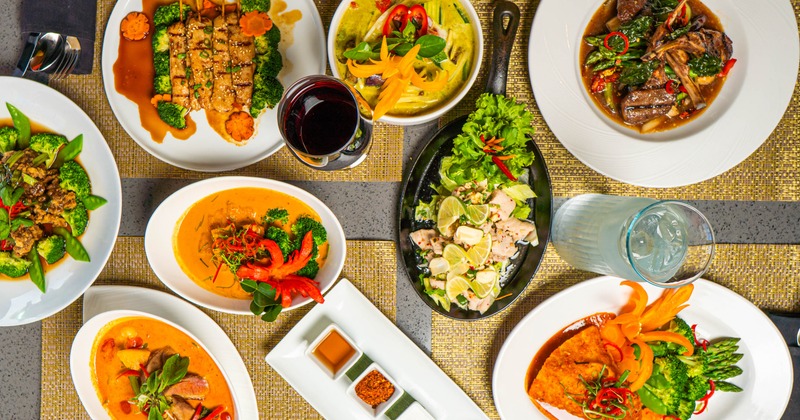 Overhead view of the various dishes, condiments and a glass of red wine