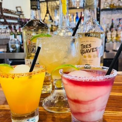 Assorted cocktail drinks displayed on bar counter.