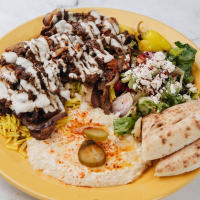 Beef Shawarma Plate featuring sides of rice, hummus, and salad.