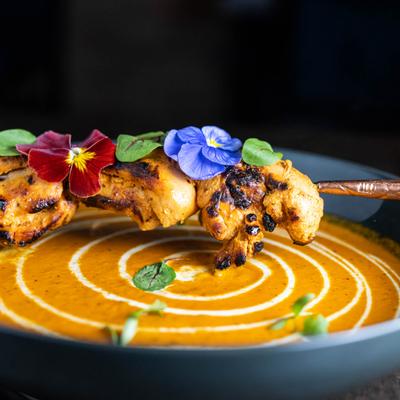 Saffron Butter Chicken, chicken skewer garnished with flowers