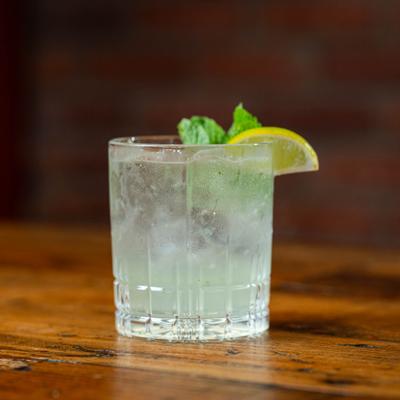 Village Mule cocktail garnished with lime wedge and a mint spring.