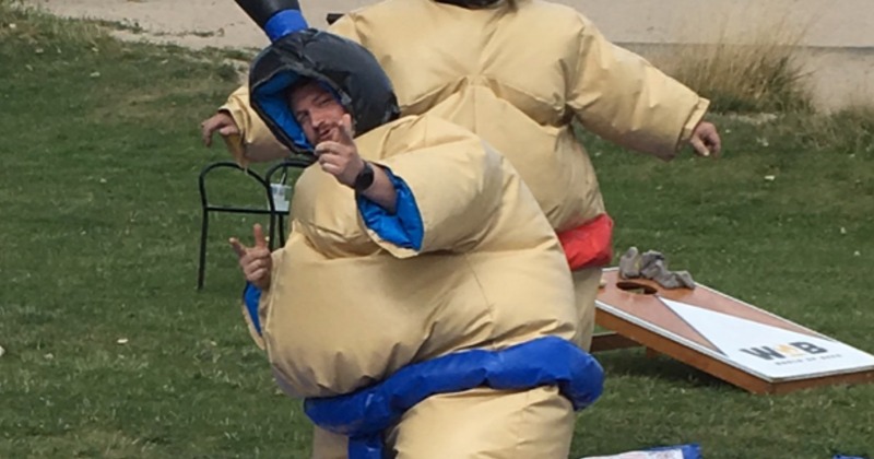 Outside, a person wearing a funny sumo suit for a  fun game of wrestling