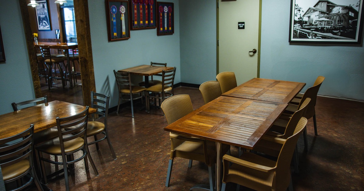 Small space with 4 brown tables that seat 4 guests per table.