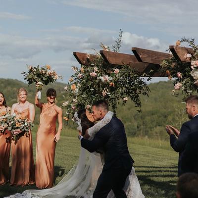The bride and groom embraced and kissing.